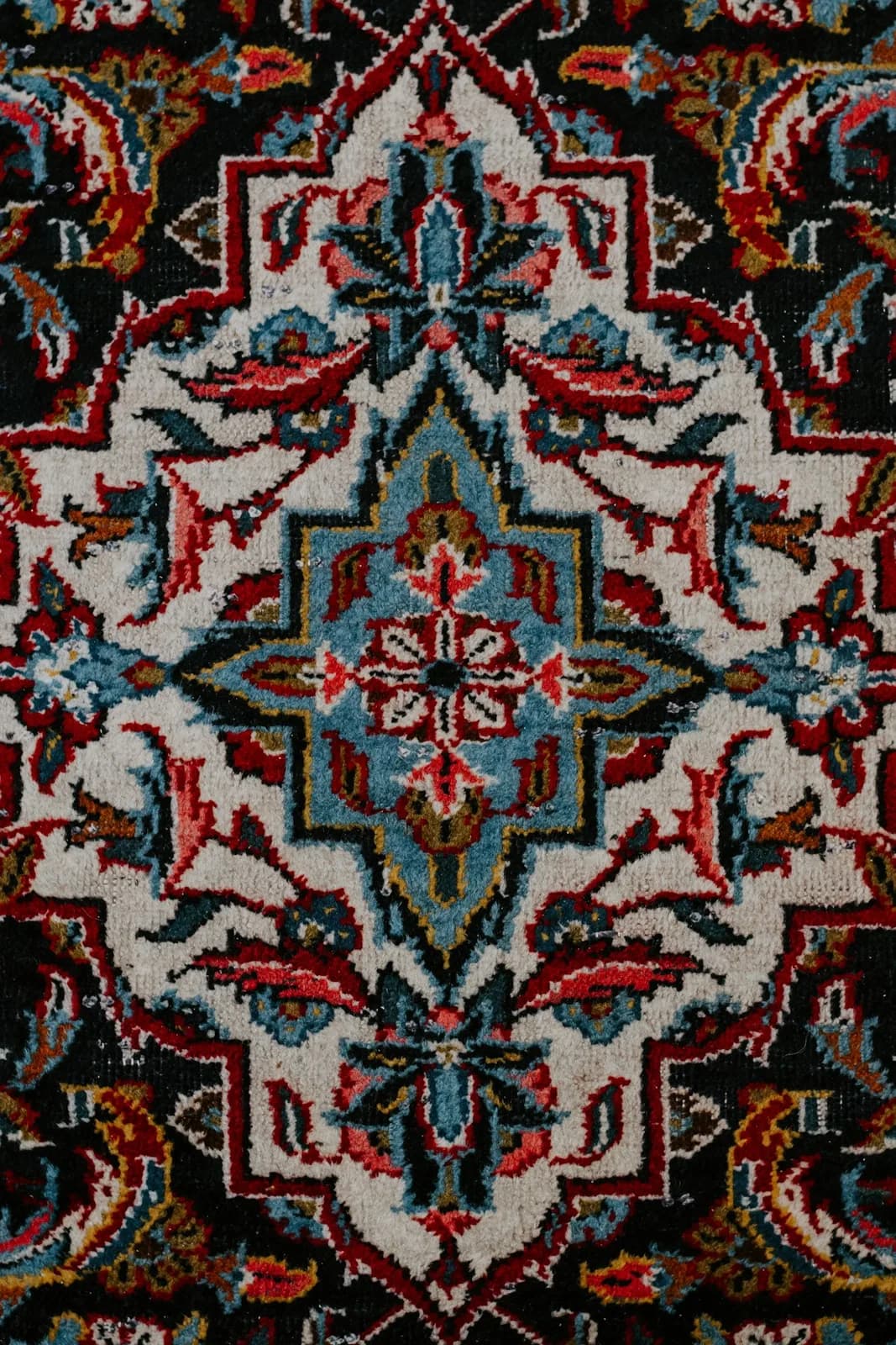 A close view of the pile of a hand-knotted wool rug, showing individual knots and the depth of the pile
